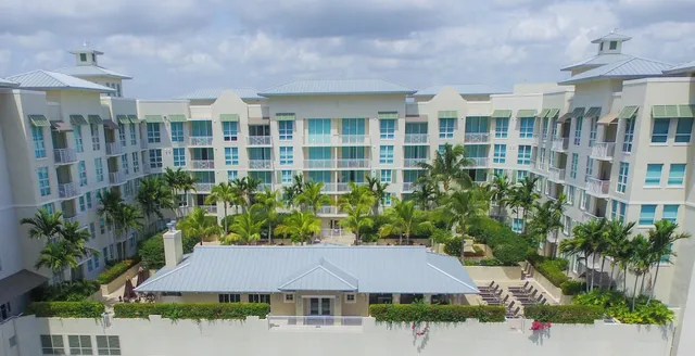 a view of a white house with a yard and plants