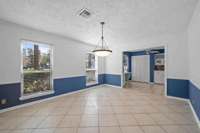 a view of empty room with cabinet and windows