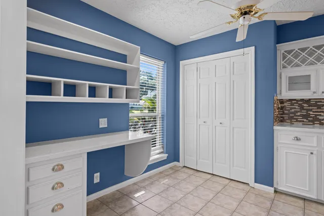 a view of an empty room with cabinet and window