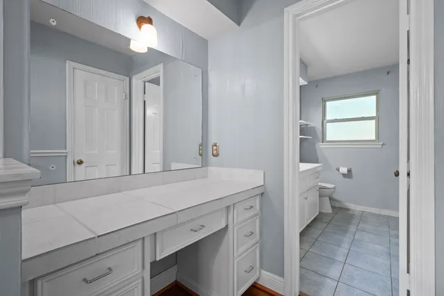 a bathroom with a sink a toilet and a mirror