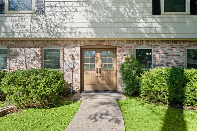 front view of a brick house with a small yard