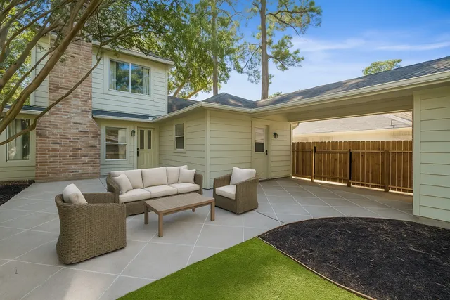 a view of a patio with couches table and chairs and potted plants