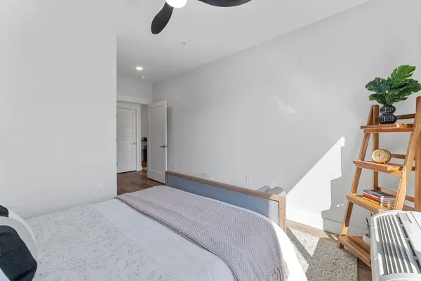 a bedroom with a bed and a potted plant