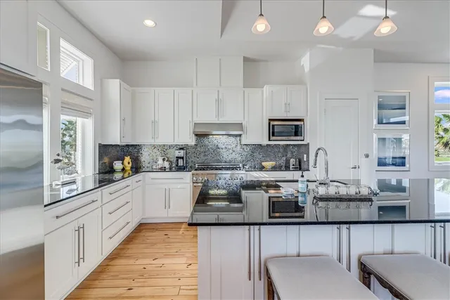 a kitchen with granite countertop white cabinets and white appliances