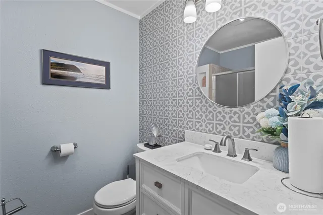 a bathroom with a sink mirror vanity and toilet