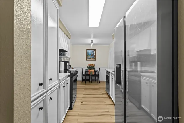 a hallway with white cabinets and couches