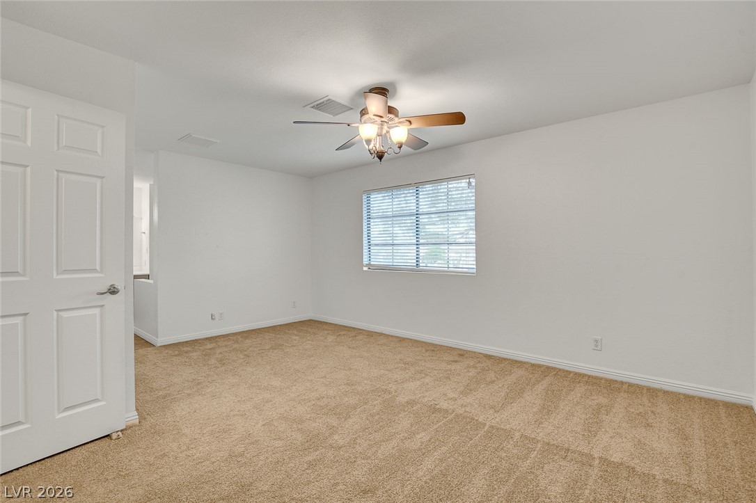1810 Pinto Road Henderson, NV 89002 - Photo 35 of 53 A well-lit room featuring neutral carpet and a window with blinds, creating a comfortable atmosphere.