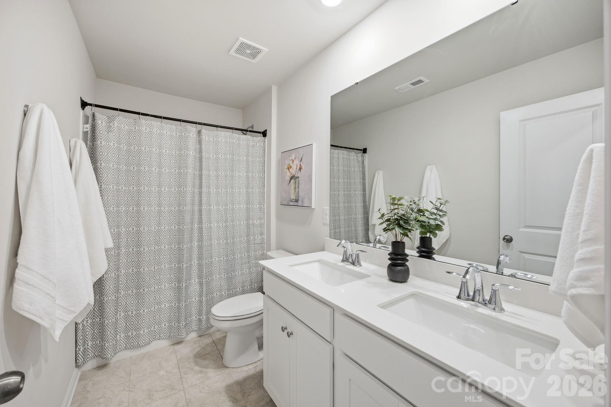 234 Hamptons Cove Road Troutman, NC 28166 - Photo 19 of 32 a bathroom with double vanity sink toilet and shower