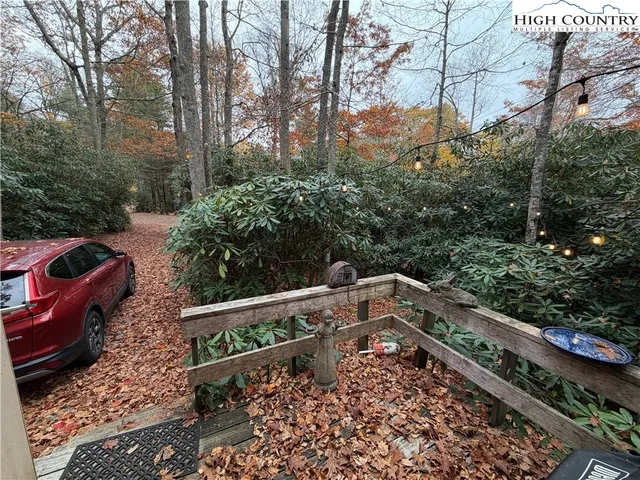 a view of a yard with plants and wooden fence