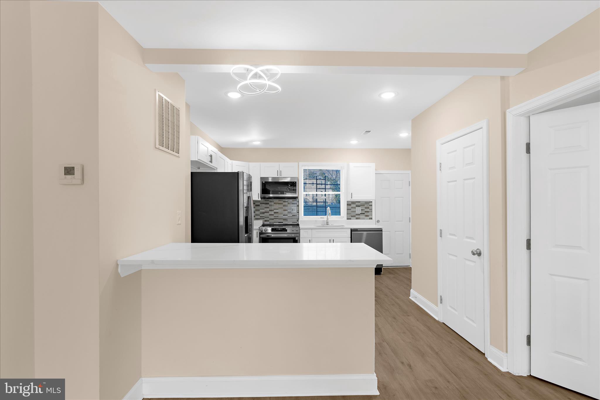 a view of kitchen with refrigerator sink and wooden floor
