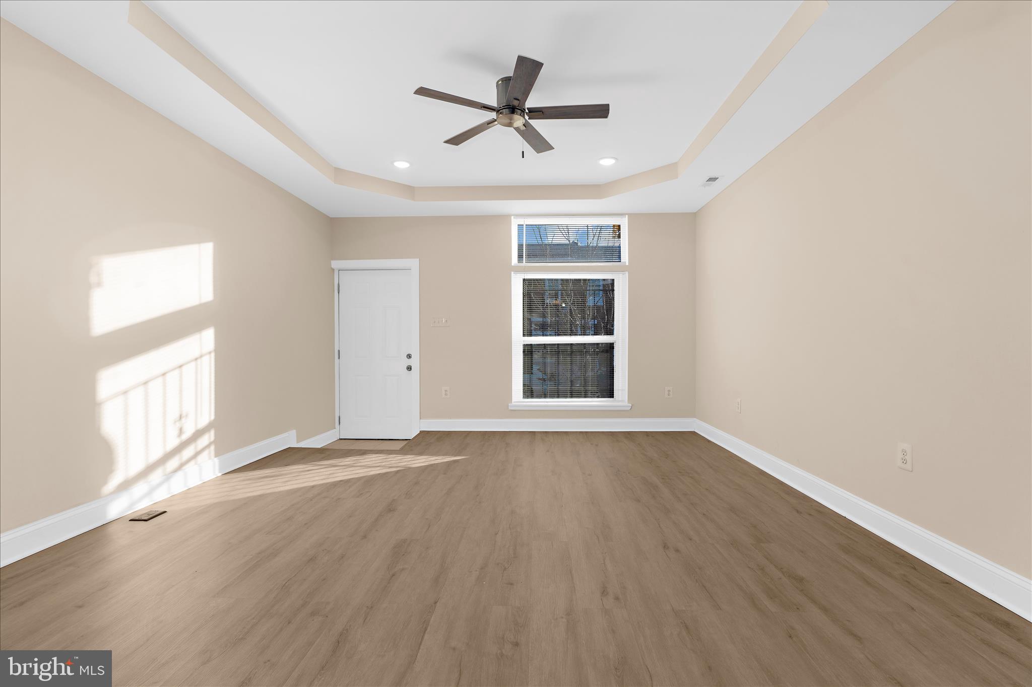 1402 North Montford Avenue Baltimore, MD 21213 - Photo 14 of 40 an empty room with wooden floor ceiling fan and windows