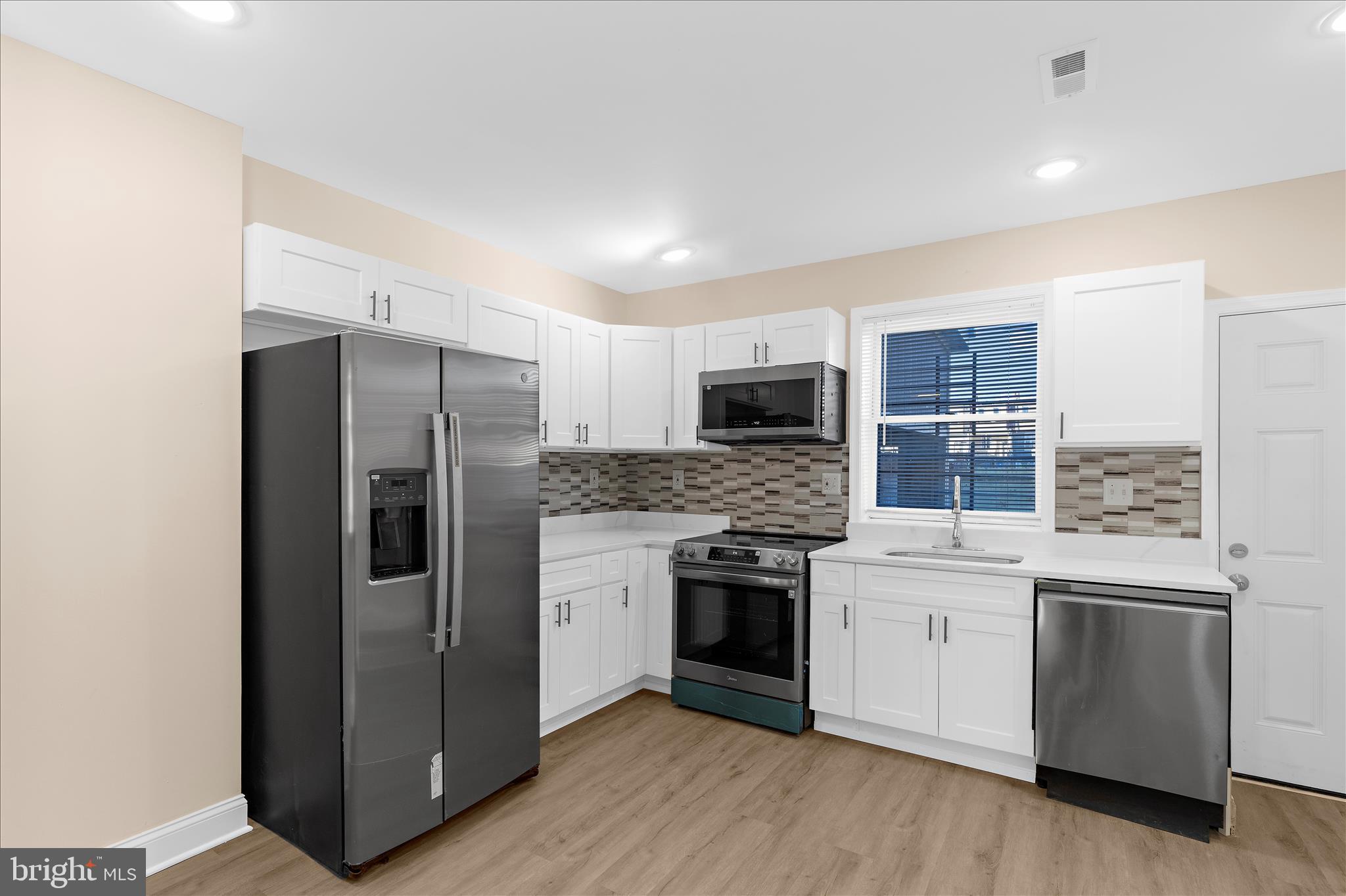 1402 North Montford Avenue Baltimore, MD 21213 - Photo 7 of 40 a kitchen with stainless steel appliances a refrigerator sink and stove