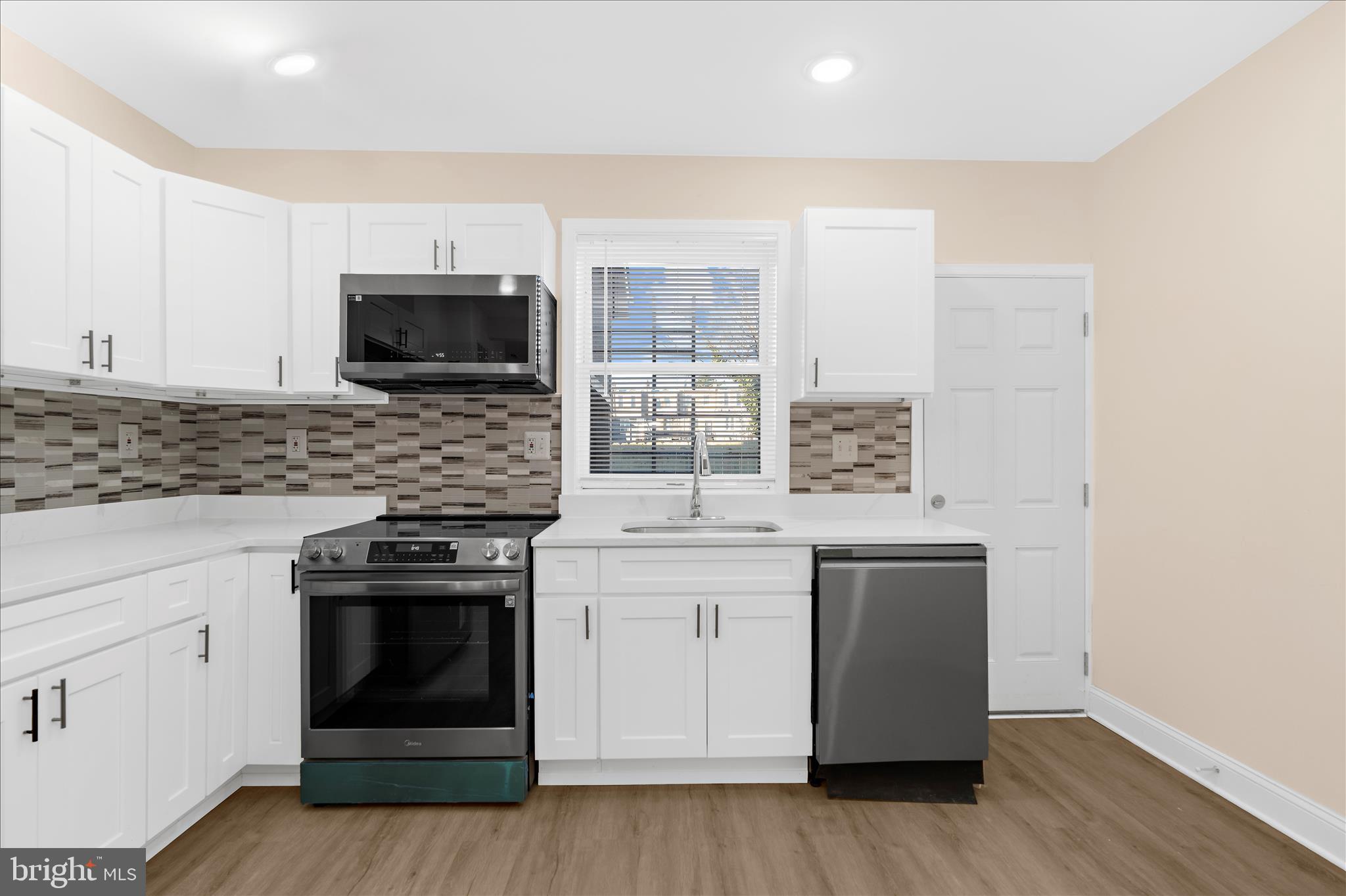 1402 North Montford Avenue Baltimore, MD 21213 - Photo 8 of 40 a kitchen with stainless steel appliances a stove sink and microwave