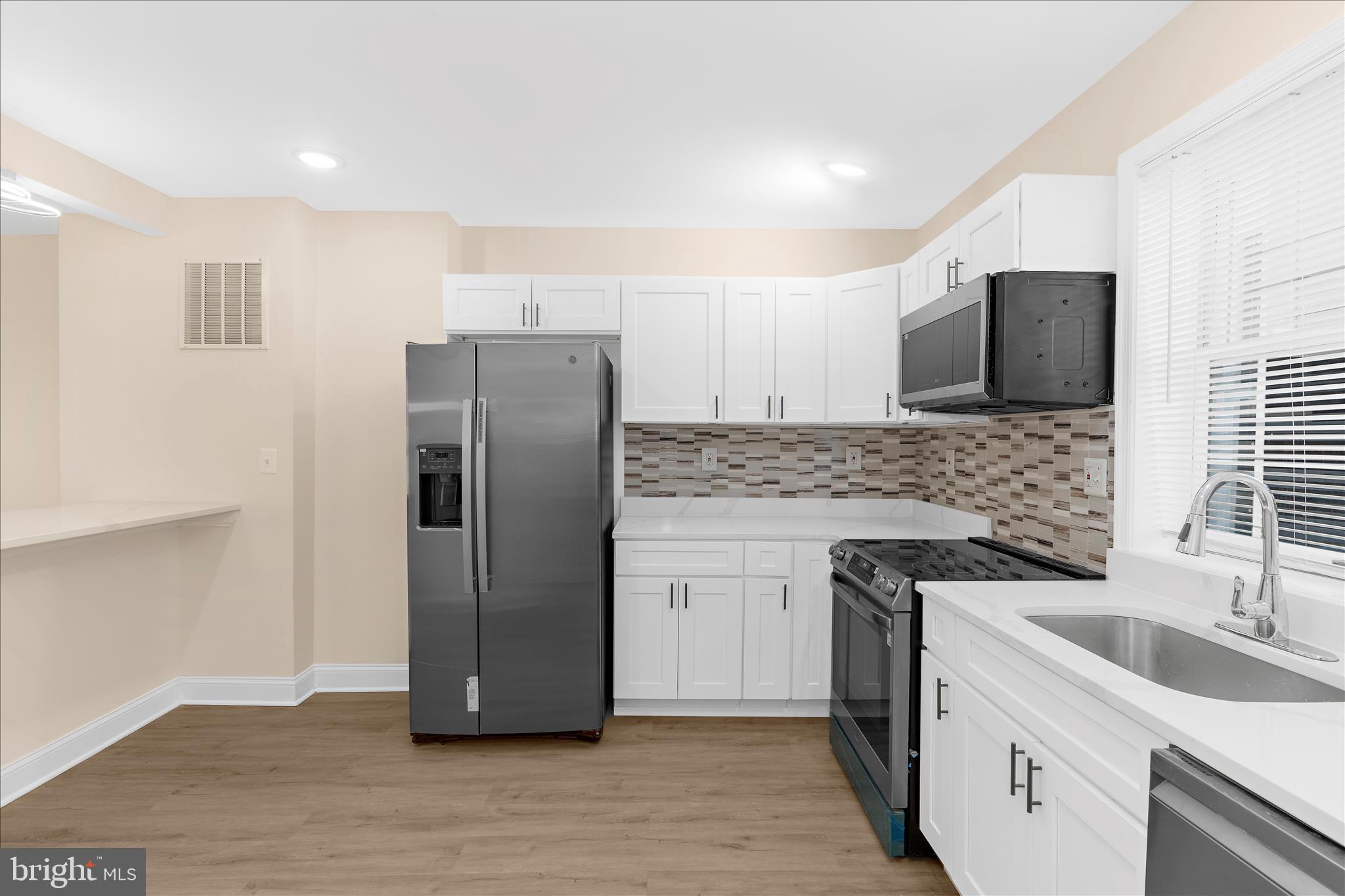 1402 North Montford Avenue Baltimore, MD 21213 - Photo 9 of 40 a kitchen with a sink stove and refrigerator