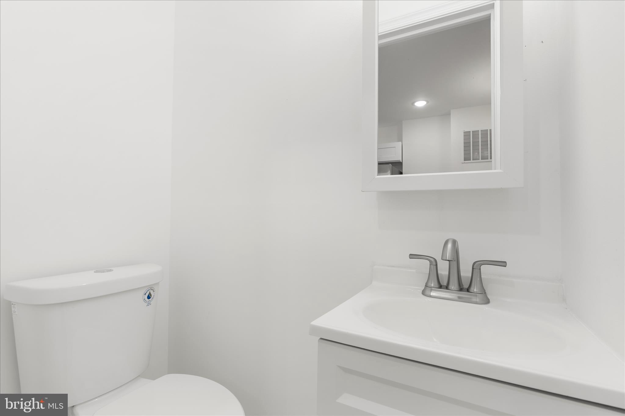 1402 North Montford Avenue Baltimore, MD 21213 - Photo 10 of 40 a bathroom with a sink a toilet and mirror