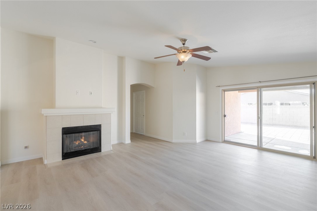 8079 Buffalo Ranch Avenue Las Vegas, NV 89147 - Photo 8 of 29 Wood-look flooring and a cozy tiled fireplace highlight this airy living room space.