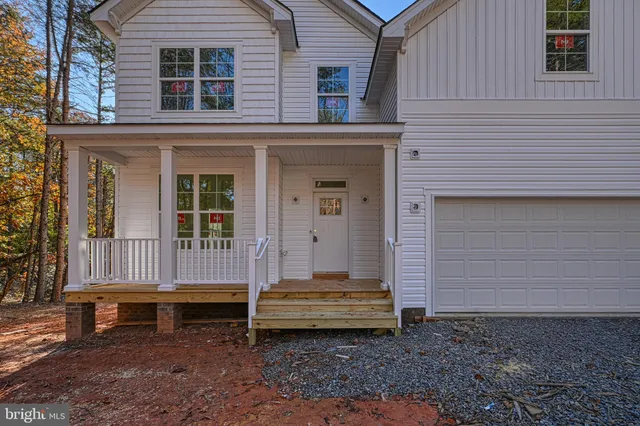 a view of a house with a yard and wooden fence