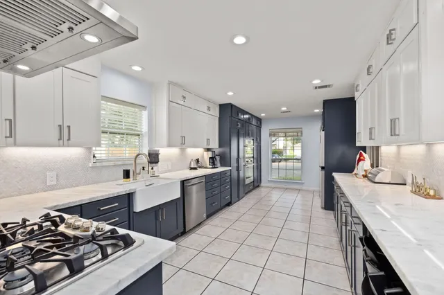 a kitchen with a sink a stove a refrigerator and a oven