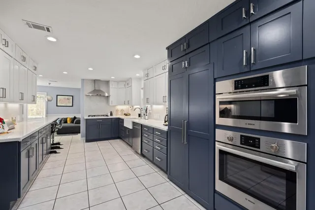 a kitchen with stainless steel appliances kitchen island granite countertop a stove a sink and a microwave