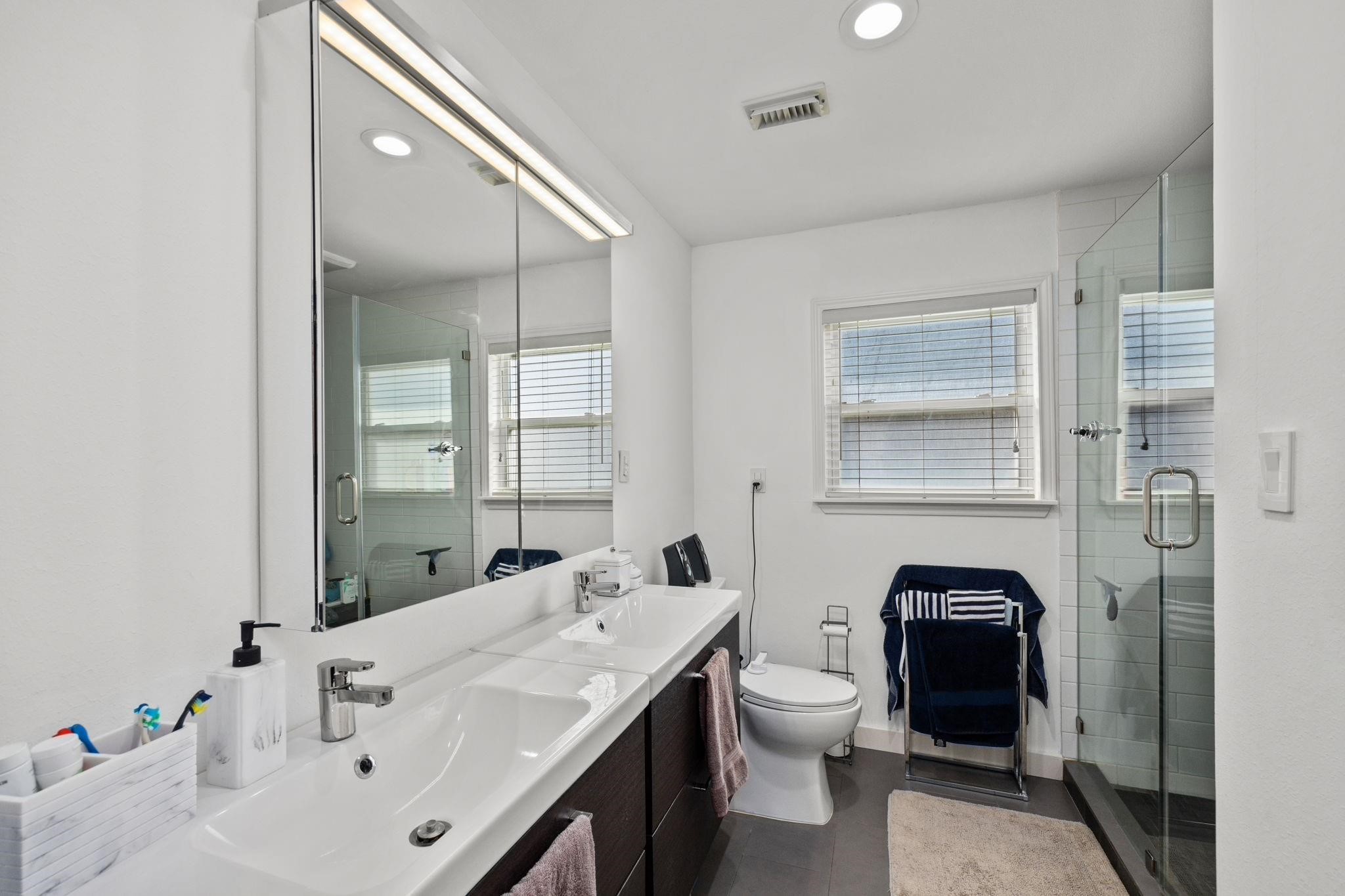 827 Thicket Lane Houston, TX 77079 - Photo 19 of 31 a bathroom with a granite countertop sink a toilet and a mirror