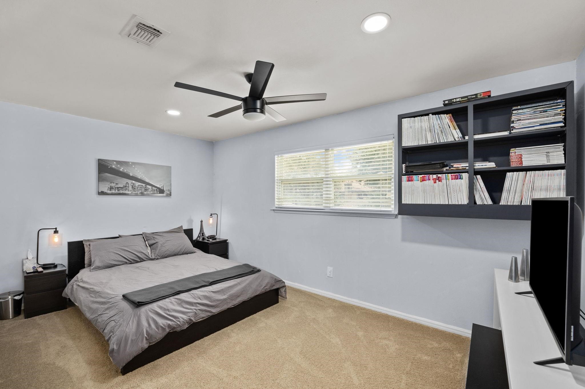 827 Thicket Lane Houston, TX 77079 - Photo 23 of 31 a bedroom with a large bed and a flat screen tv