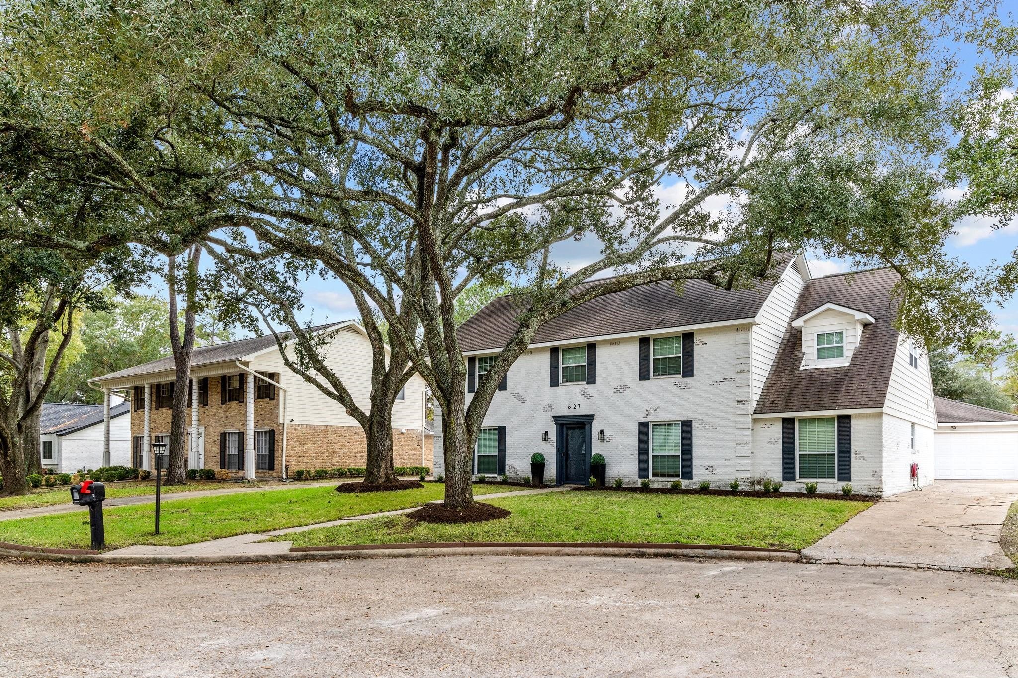 827 Thicket Lane Houston, TX 77079 - Photo 3 of 31 a front view of a house with a yard and large trees