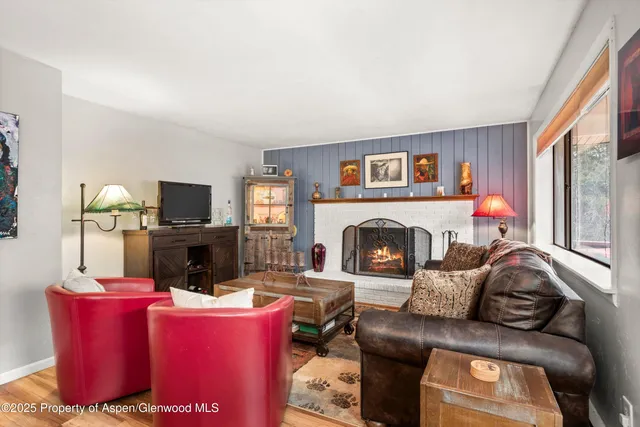 a living room with furniture a flat screen tv and a fireplace