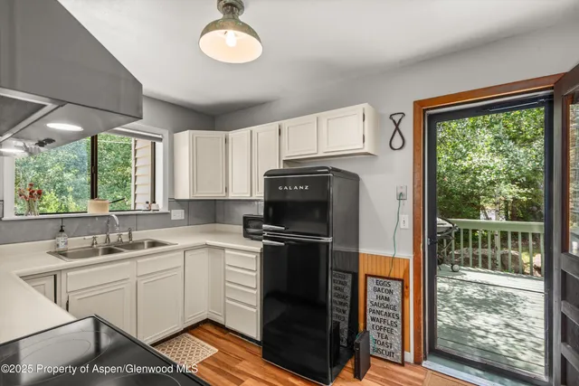 a kitchen with a sink cabinets stainless steel appliances and a large window