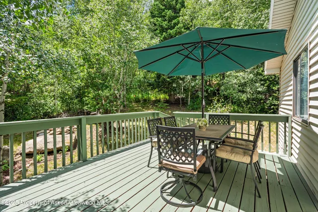 a view of a deck with furniture and barbeque grill with wooden floor and fence