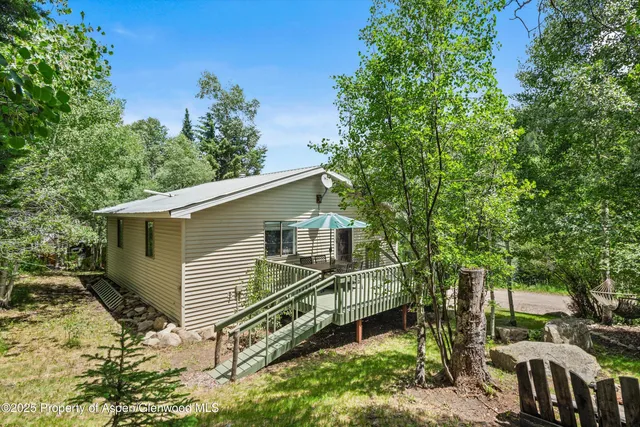 a view of a house with a yard and trees