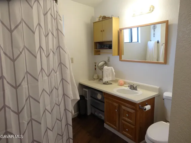 a bathroom with a sink a toilet and a mirror