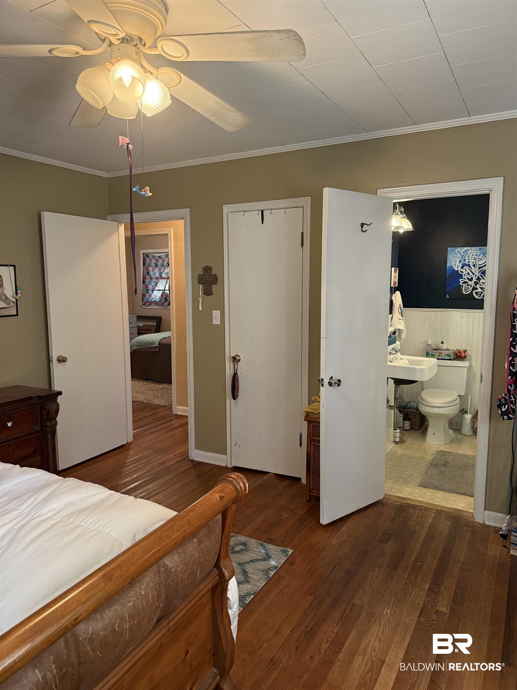 22173 1st Street Silverhill, AL 36576 - Photo 8 of 16 Bedroom featuring ornamental molding, dark wood-style floors, ceiling fan, ensuite bath, and wainscoting