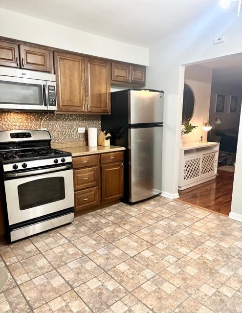 491 McHenry Road, Unit 3A Wheeling, IL 60090 - Photo 16 of 17 a kitchen with granite countertop a refrigerator and a stove top oven