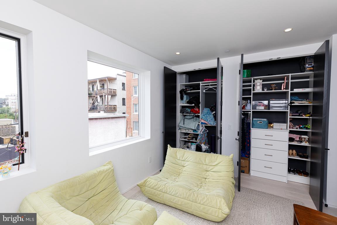 1321 Monroe Street Northwest, Unit PH Washington, DC 20010 - Photo 19 of 40 a bedroom with furniture and a book shelf