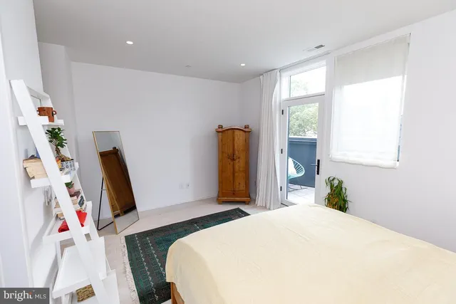a bedroom with a bed and a flat tv screen on the dresser