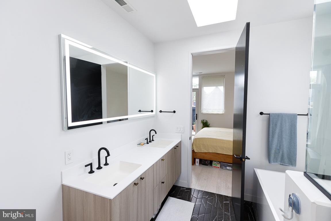 1321 Monroe Street Northwest, Unit PH Washington, DC 20010 - Photo 28 of 40 a bathroom with a tub sink and mirror