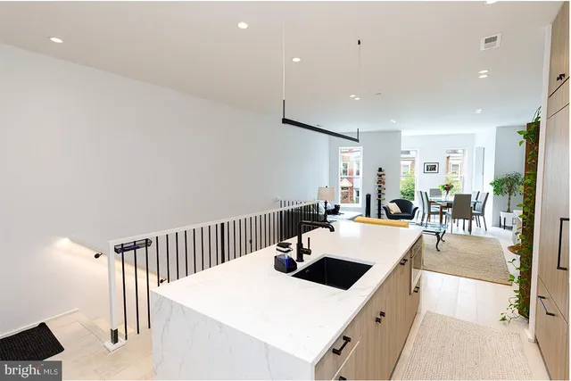 a large white kitchen with sink a counter top space and appliances
