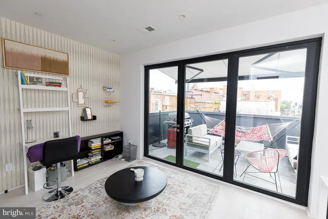 a view of a porch with furniture and floor to ceiling window