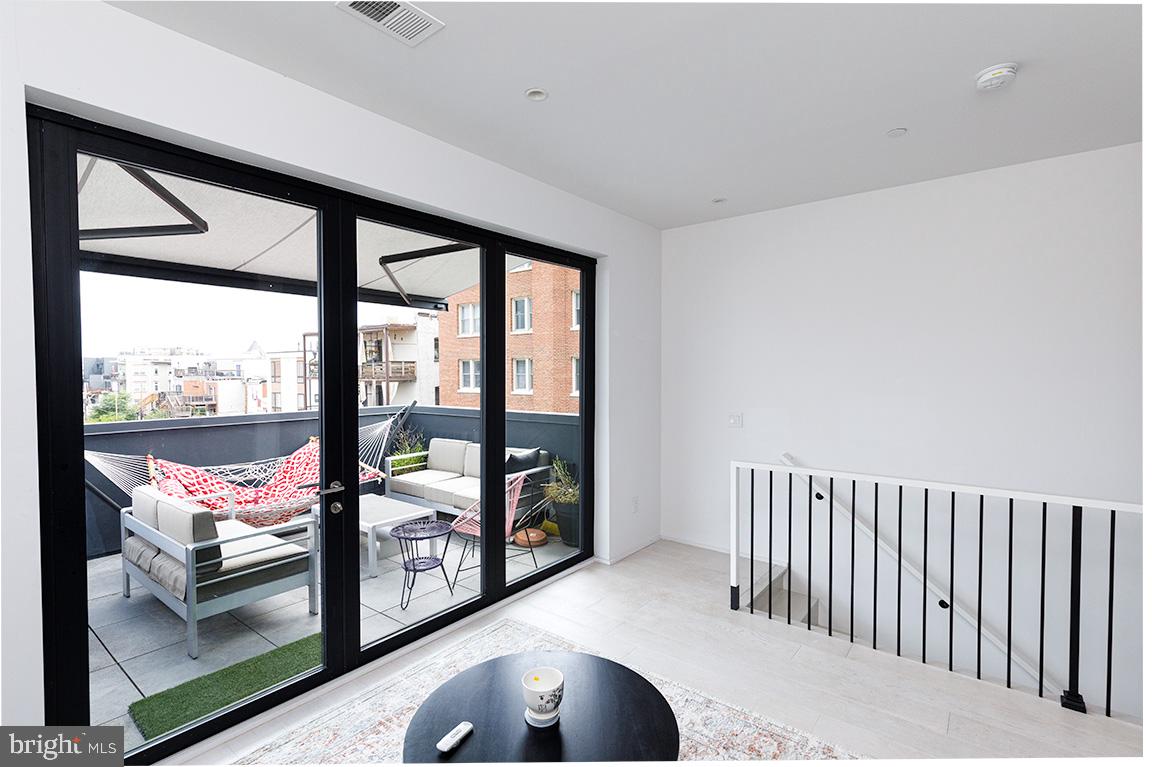 1321 Monroe Street Northwest, Unit PH Washington, DC 20010 - Photo 35 of 40 a view of a porch with furniture and floor to ceiling window