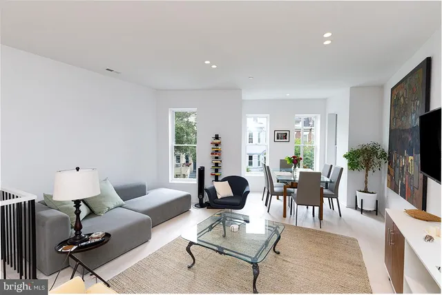 a living room with furniture a flat screen tv and a large window