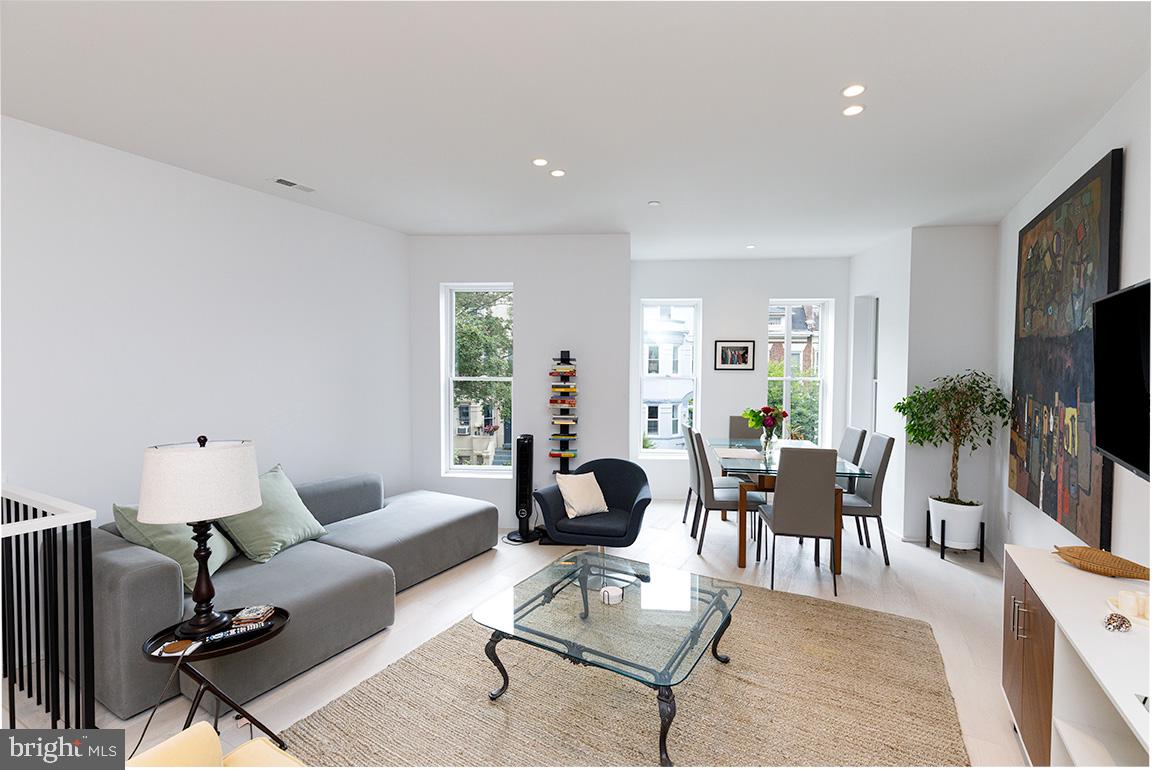 1321 Monroe Street Northwest, Unit PH Washington, DC 20010 - Photo 5 of 40 a living room with furniture a flat screen tv and a large window