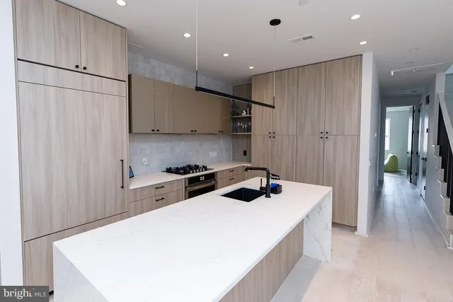a kitchen with a white center island a stove and a refrigerator