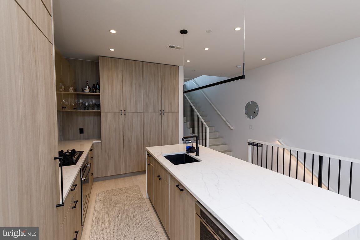 1321 Monroe Street Northwest, Unit PH Washington, DC 20010 - Photo 10 of 40 a kitchen with kitchen island stainless steel appliances sink refrigerator and stove