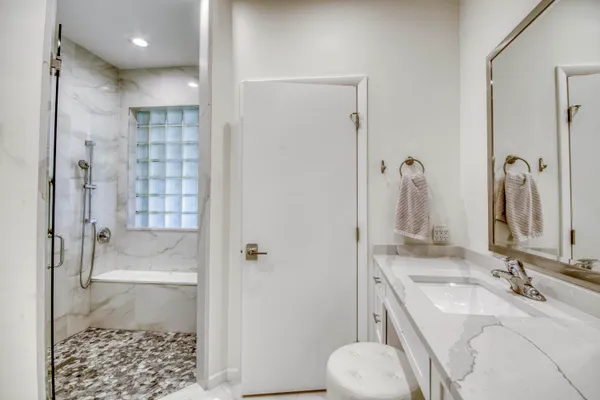 a bathroom with a granite countertop sink toilet and shower