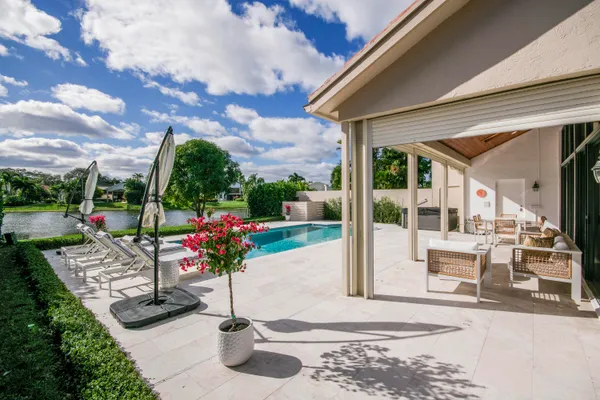 a view of a patio with a dining table and chairs under an umbrella