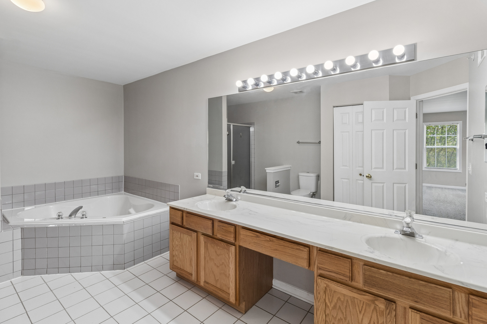2075 Ivy Ridge Drive Hoffman Estates, IL 60192 - Photo 19 of 20 a spacious bathroom with a double vanity sink mirror and bathtub
