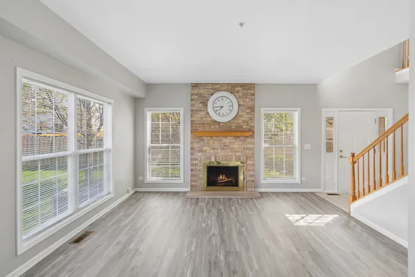 a view of empty room with wooden floor and fireplace