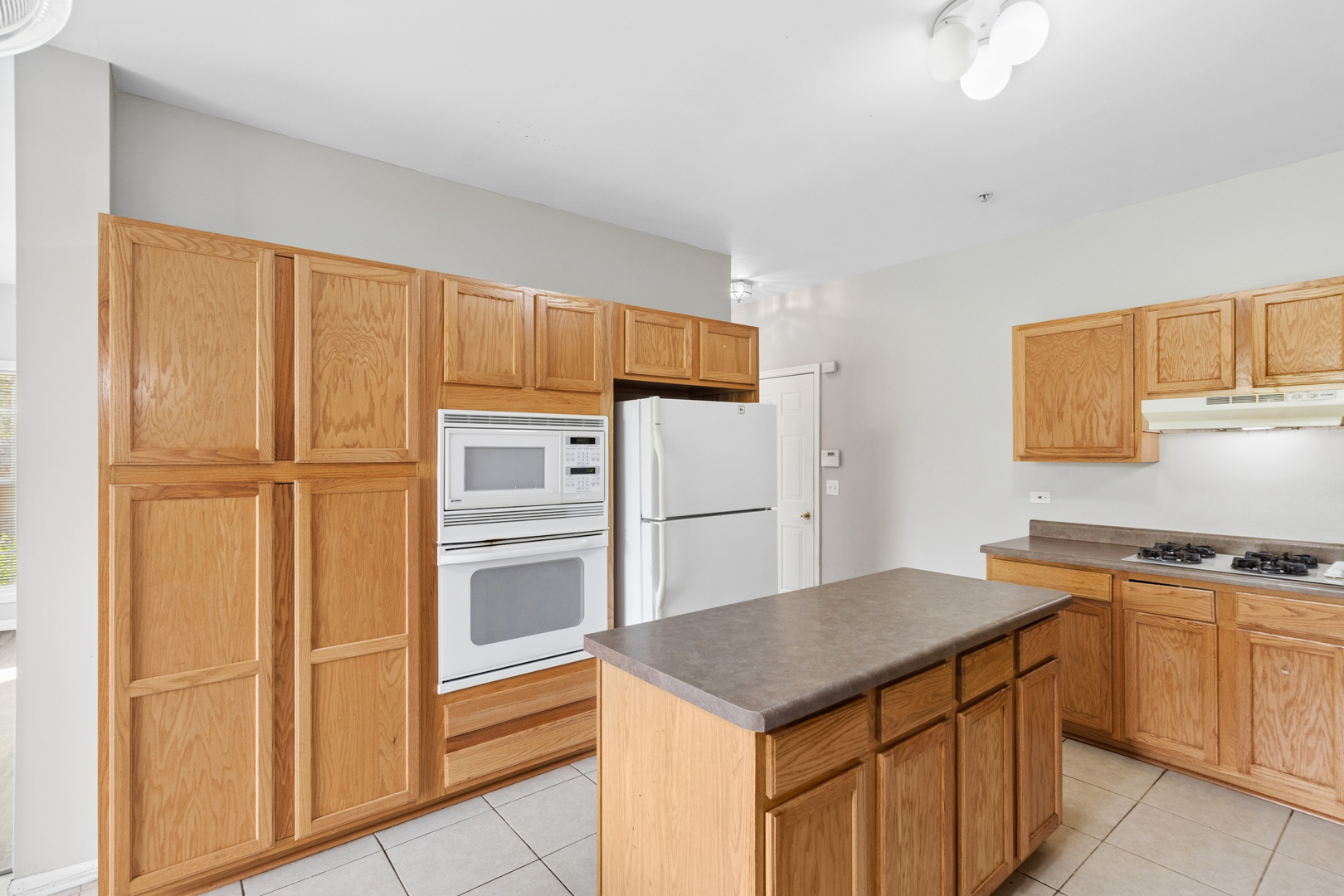 2075 Ivy Ridge Drive Hoffman Estates, IL 60192 - Photo 8 of 20 a kitchen with kitchen island granite countertop wooden cabinets and refrigerator