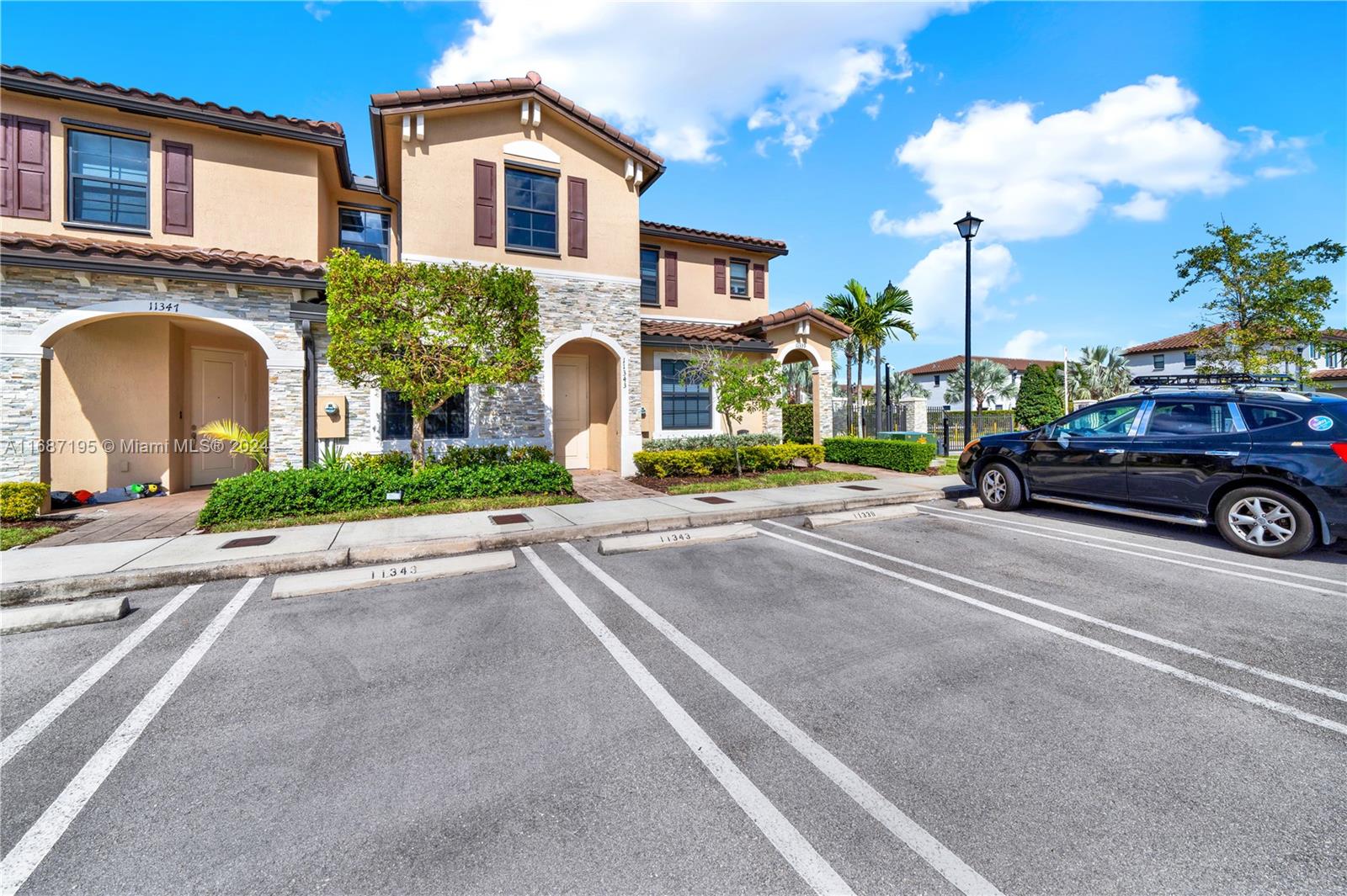 11343 Southwest 250th Terrace, Unit 11343 Homestead, FL 33032 - Photo 29 of 37 a front view of a house with a yard and parking