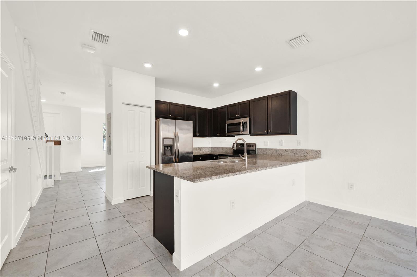 11343 Southwest 250th Terrace, Unit 11343 Homestead, FL 33032 - Photo 10 of 37 a kitchen with stainless steel appliances a sink stove and refrigerator